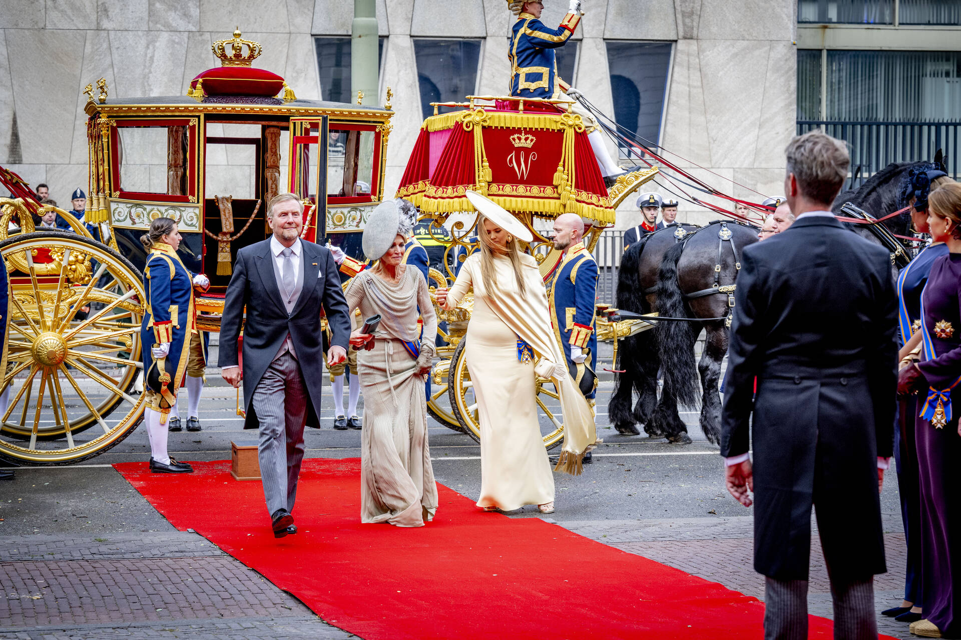 De commissie van in- en uitgeleide staat klaar wanneer de Koninklijke Stoet bij de Schouwburg arriveert. 