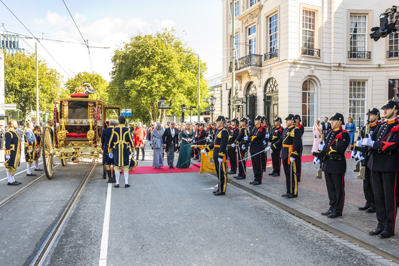 Koning, koningin en prinses van Oranje groeten het vaandel bij aankomst bij de Koninklijke Schouwburg op Prinsjesdag in 2022