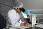 Onderzoeker in een laboratorium met een microscoop